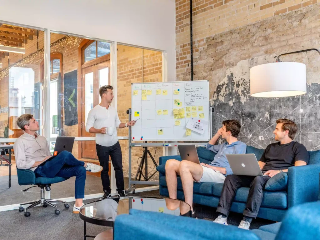 Team members discussing a project in front of a whiteboard in an office